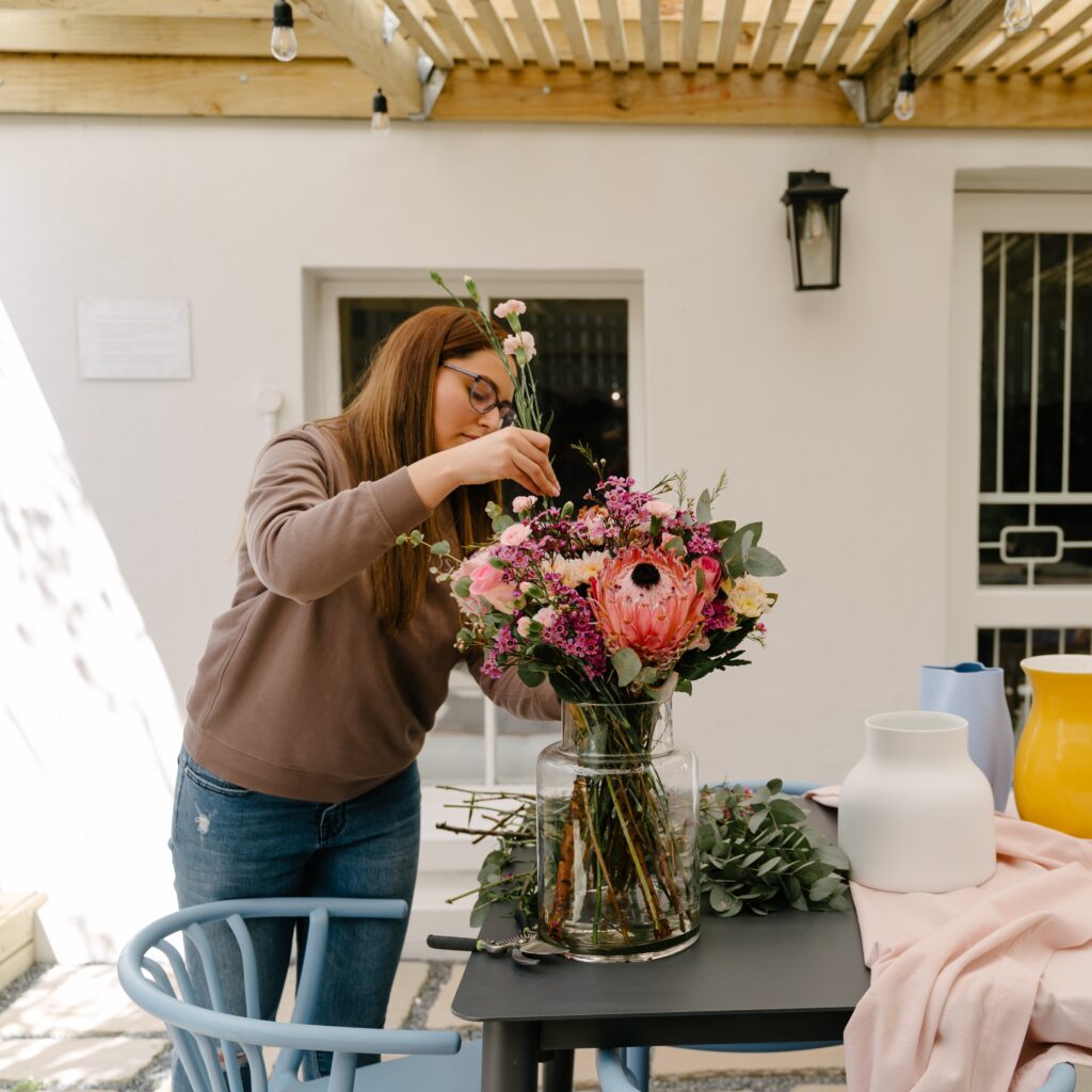 Behind-the-scenes florist arranging fresh flowers at Petal & Post